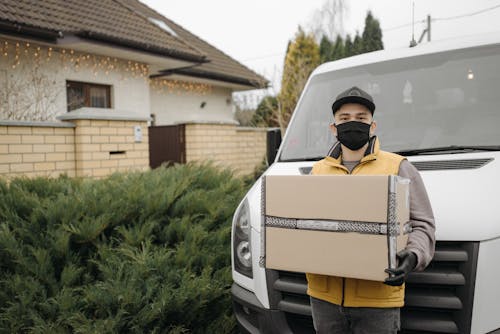 Free Deliveryman Carrying a Cardboard Box Stock Photo