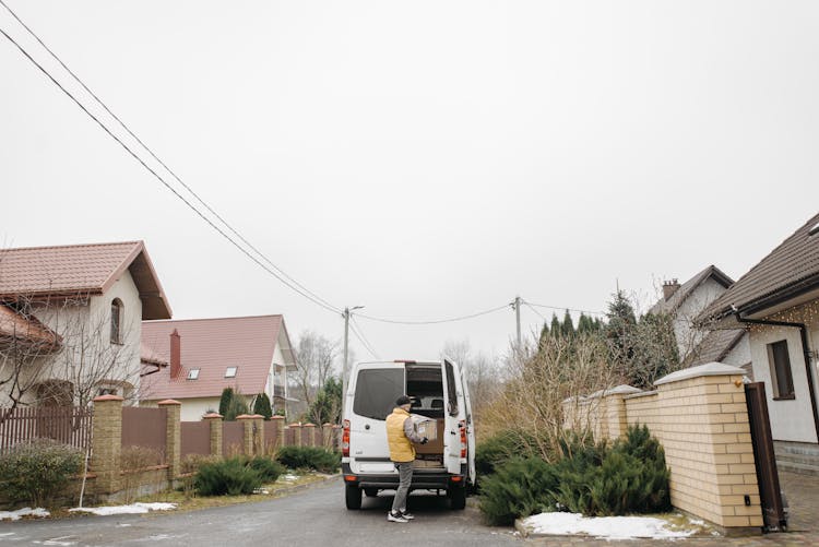 A Deliveryman Taking A Box From The Van