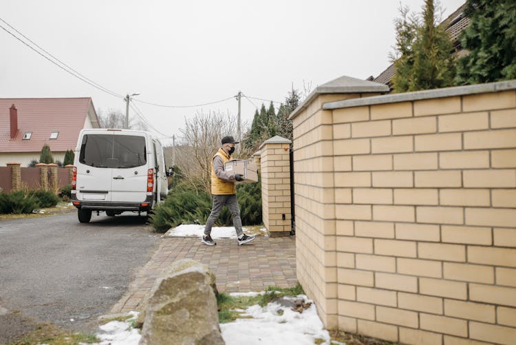 Man Delivering A Package At A House