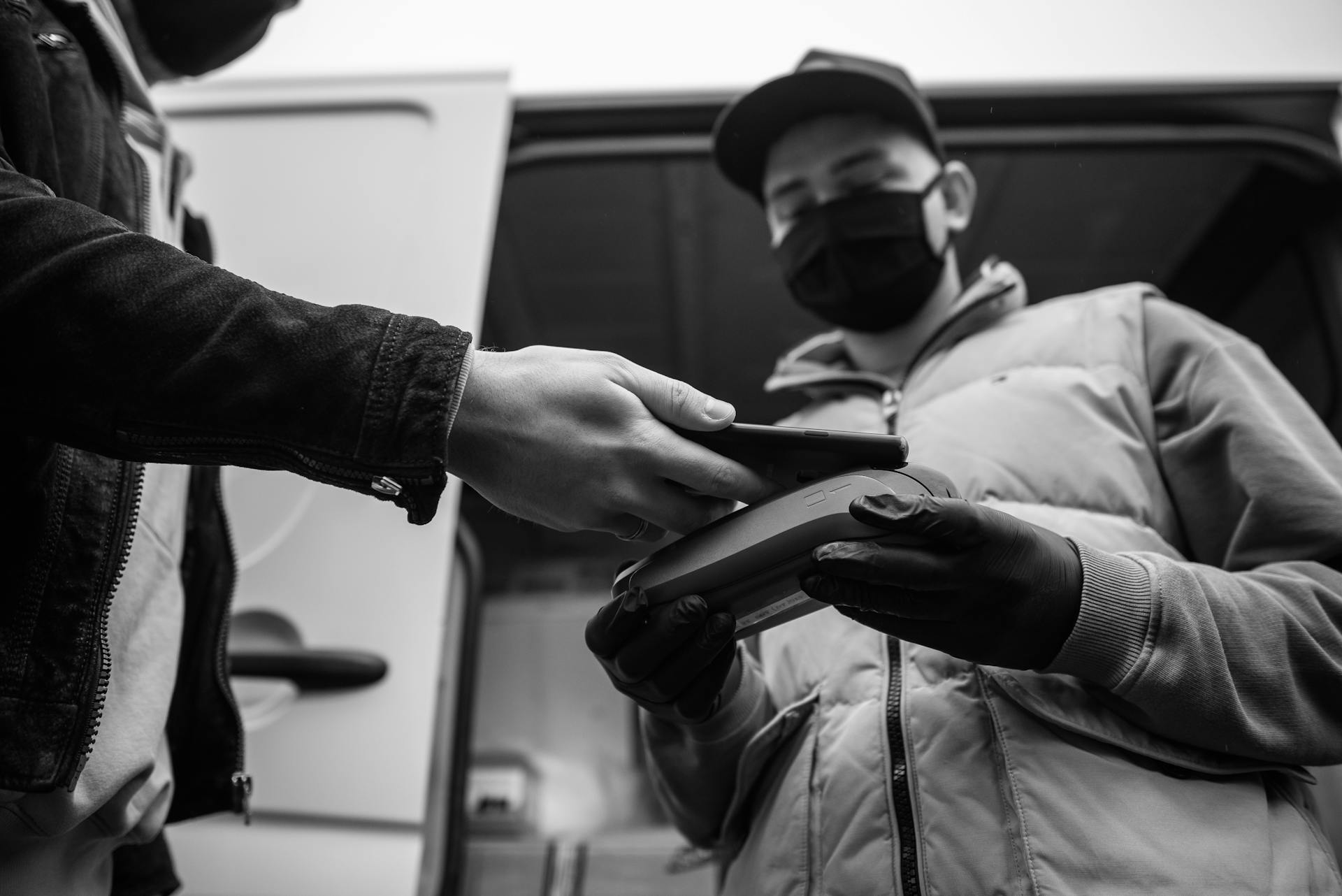 Grayscale Photography of a Person Making Contactless Payment