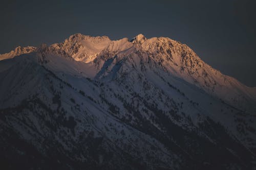 Scenic snowy mountain landscape under blue sundown sky