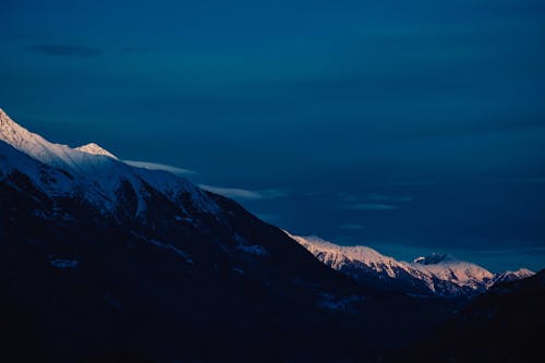 雪覆蓋山在藍藍的天空下