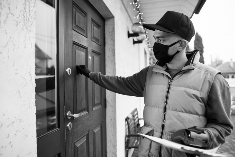 Uninvited contractor knocking on a homeowner's front door after a storm Uninvited contractor knocking on a homeowner's front door after a storm