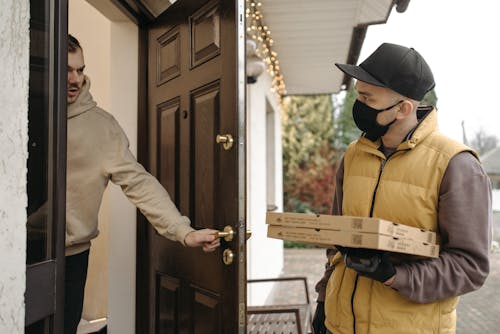 Man Wearing Black Cap Delivering Pizza