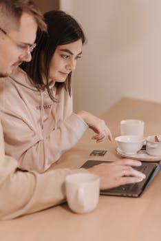 Young couple enjoying online shopping with coffee in a cozy home setting.