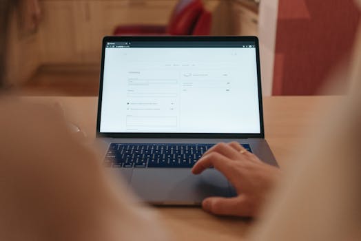 Close-up of a person navigating online checkout on a laptop screen in a cozy indoor setting.
