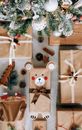 Top view composition of many gift boxes wrapped in craft paper and placed on floor underneath sparkling decorated Christmas tree