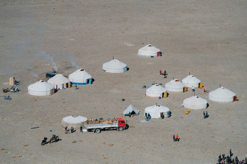 Free Aerial view of traditional yurts and people in a remote desert setting. Stock Photo