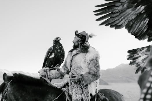 Capture of a Kazakh man in traditional attire with his eagle in a vast landscape.