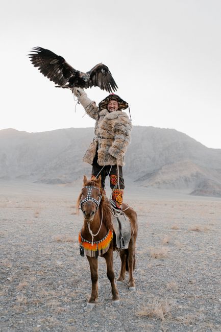 Mongolian hunter with eagle on horseback, showcasing cultural heritage and freedom.