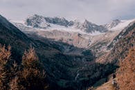 雪山与充满活力的秋季森林在宁静山谷中令人惊叹