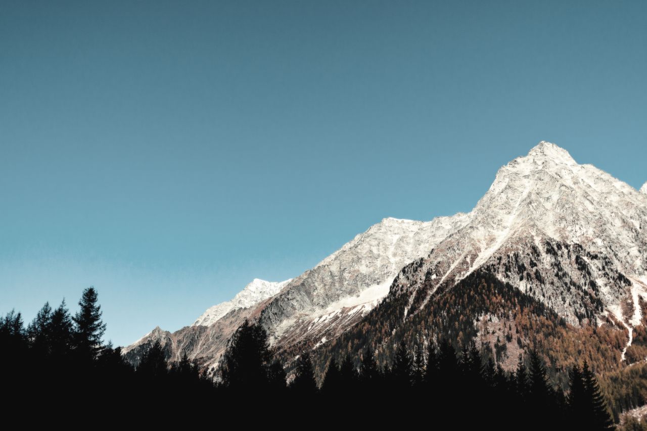 breathtaking view of snow capped mountains and forest at sunrise ideal