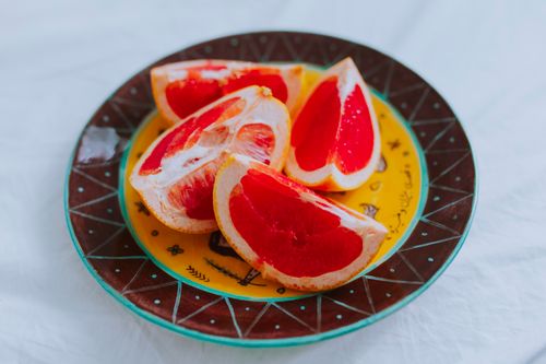 Free Fresh grapefruit slices on a colorful ceramic plate, perfect for healthy eating concepts. Stock Photo