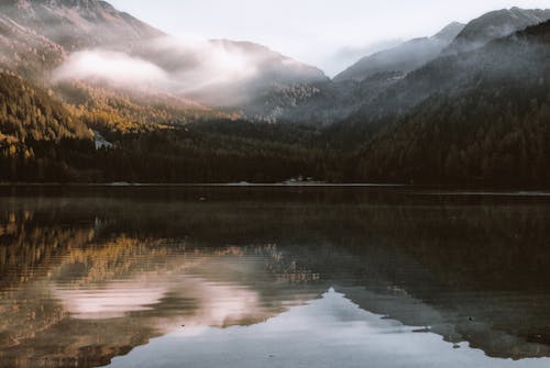 Free Mountain Reflection on Body of Water Under White Sky at Stock Photo