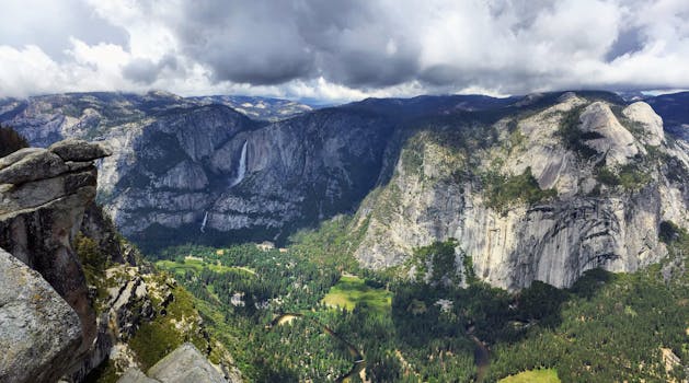 Beautiful view of Yosemite Valley with mountains, trees, and dramatic clouds in California.