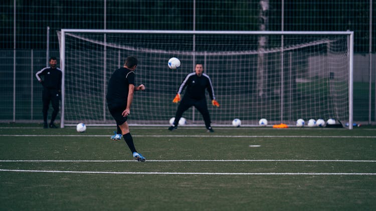 Team Playing Football On Sports Field