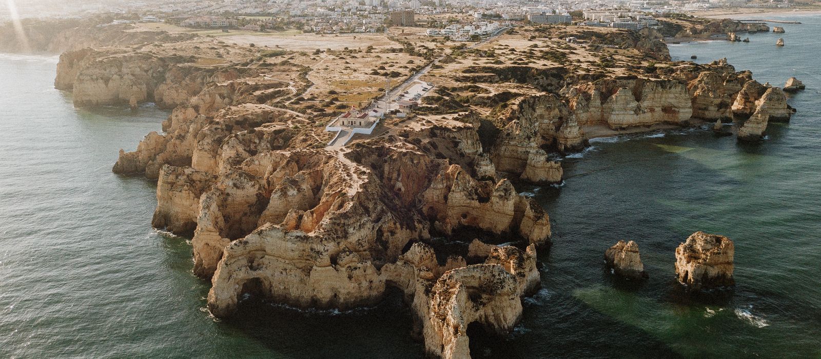 Aerial view of the stunning cliffs and coastline of Algarve, Portugal, with crystal clear sea water.
