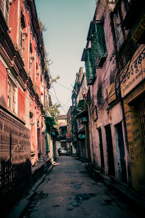 Free Shabby buildings with narrow paved street located in old poor district of city on day with good weather Stock Photo