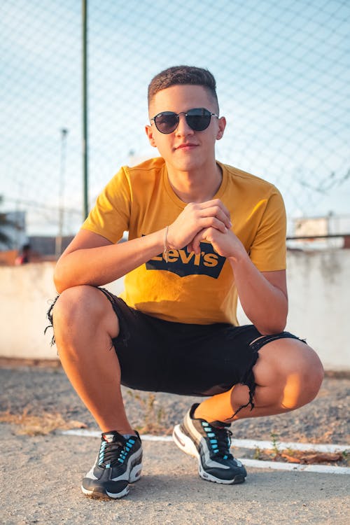 Teenage Boy in Yellow Shirt and Black Shorts 