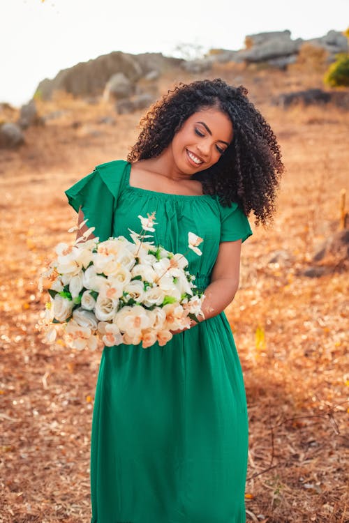 Free Woman in Green Dress Holding A Bouquet of Flowers Stock Photo
