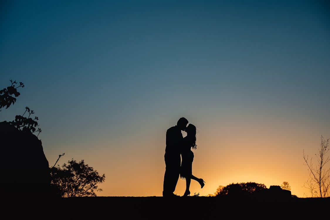 Foto profissional grátis de amor, ao ar livre, beijando