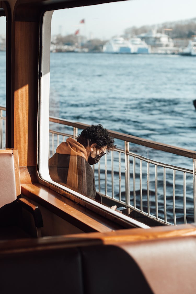 Unrecognizable Guy Using Phone In Ferry Near Water