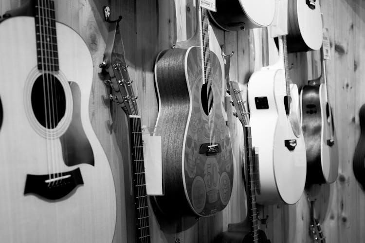 Gray Scale Photo Of Acoustic Guitars