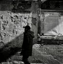 Man Walking Against an Old Weathered Wall on a Street