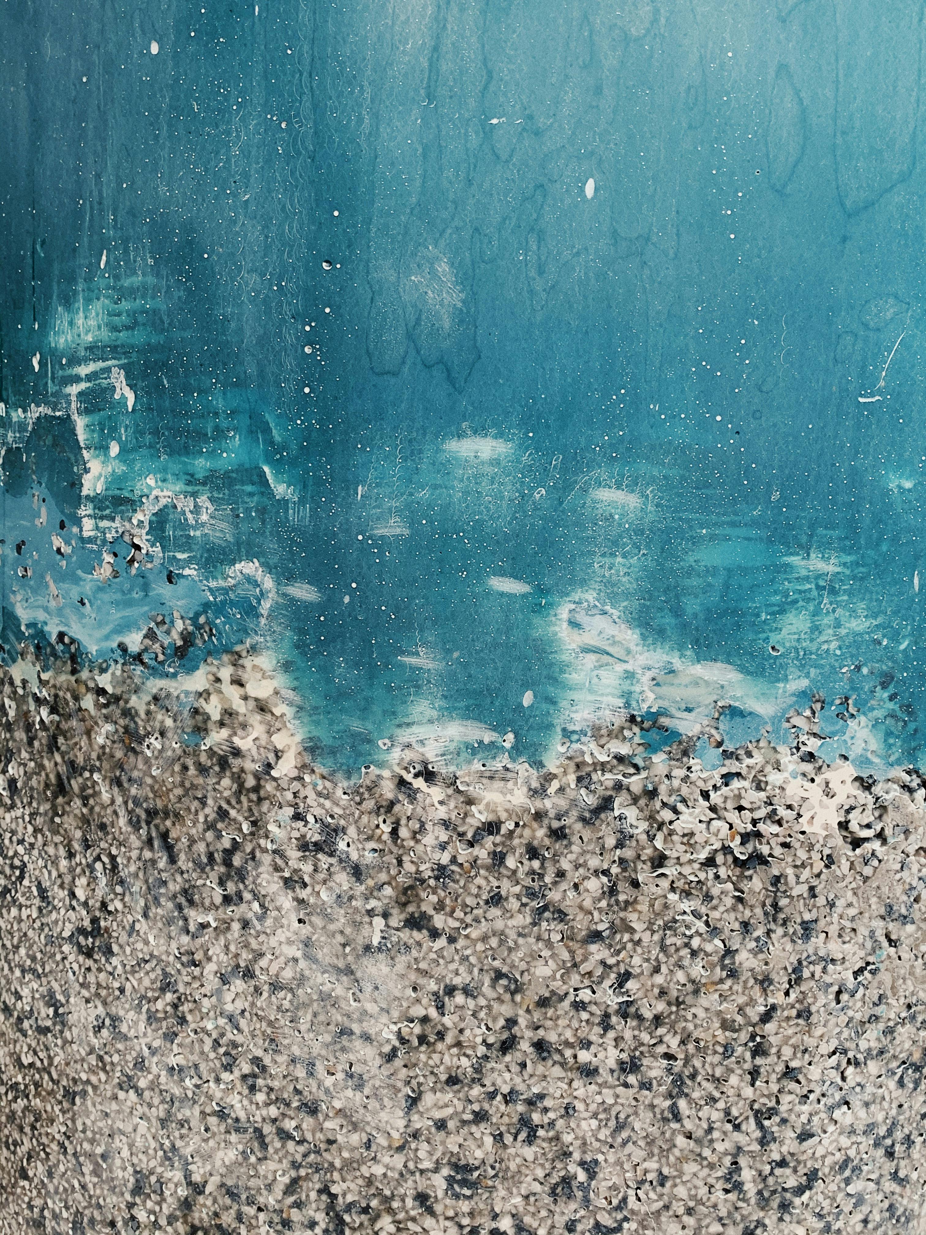 Close-up of a textured blue wall with peeling paint creating a rough pattern.