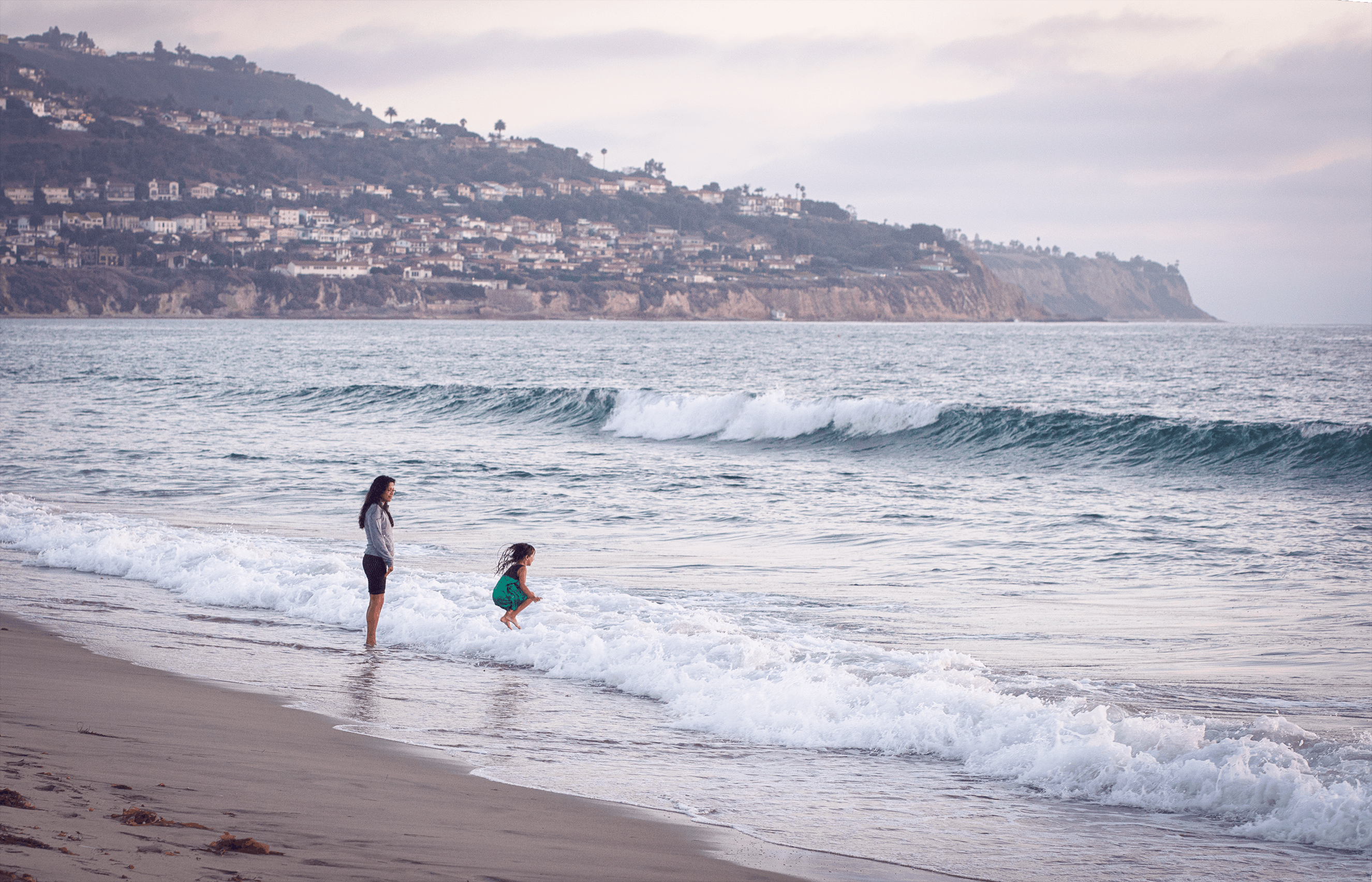 a woman and a young girl on the beach