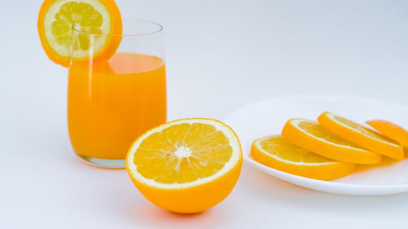 glasses of fresh green juice and orange carrot juice on a wooden table