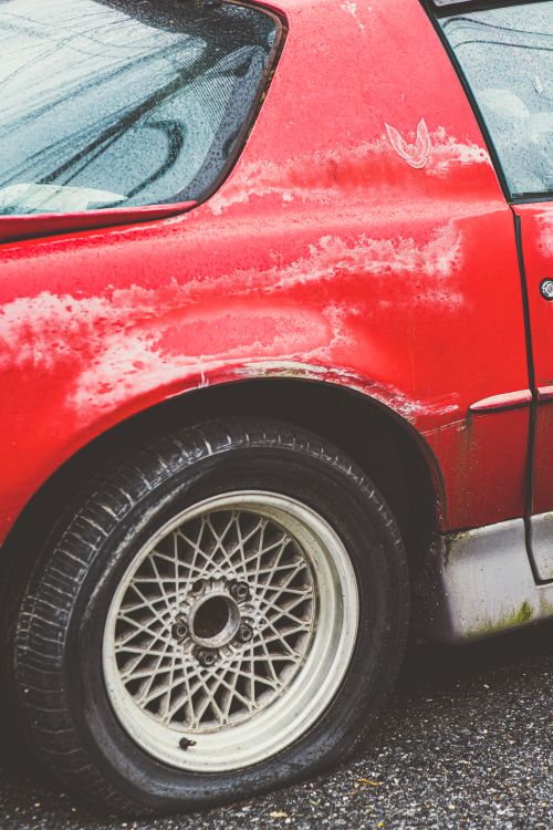 A Red Car With a Flat Tire · Free Stock Photo