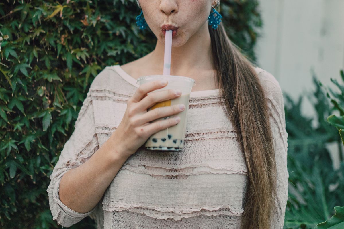 An iced matcha latte in a glass on a light background.