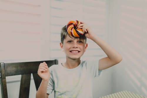 
A Boy Holding a Colorful Bagel