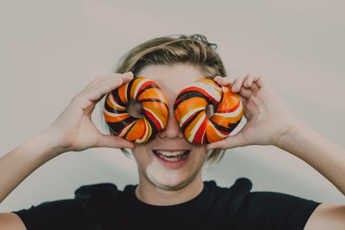 
A Boy Holding Colorful Bagels