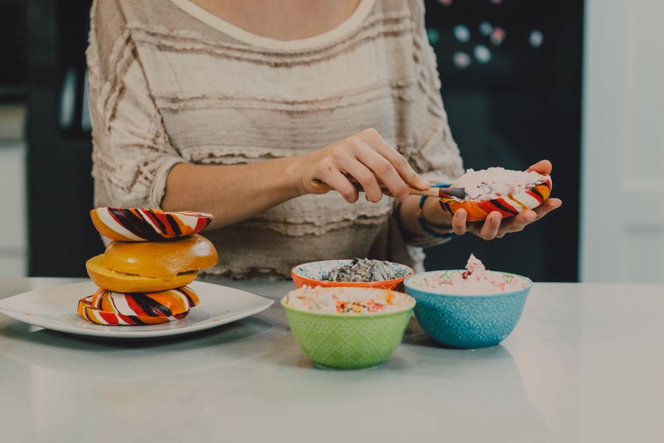 Jeff’s Bagel Run Introduces Spring Menu 2 A vibrant breakfast setup featuring rainbow bagels and flavored cream cheese varieties, perfect for a morning treat. | BocaVibe