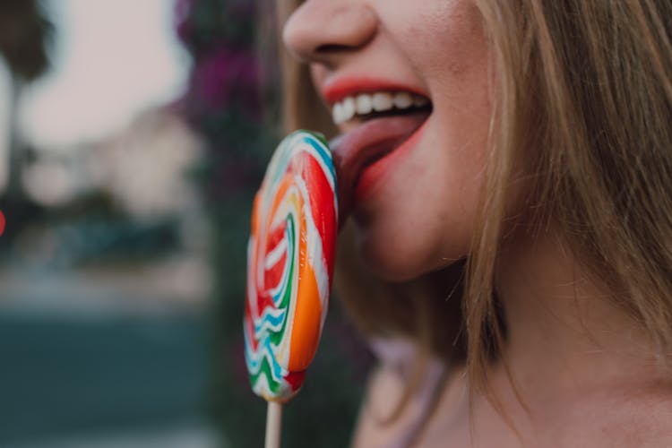 A Woman Licking A Lollipop