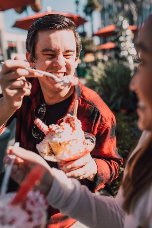 Free Friends enjoying a refreshing ice cream together outdoors, capturing fun and happiness. Stock Photo