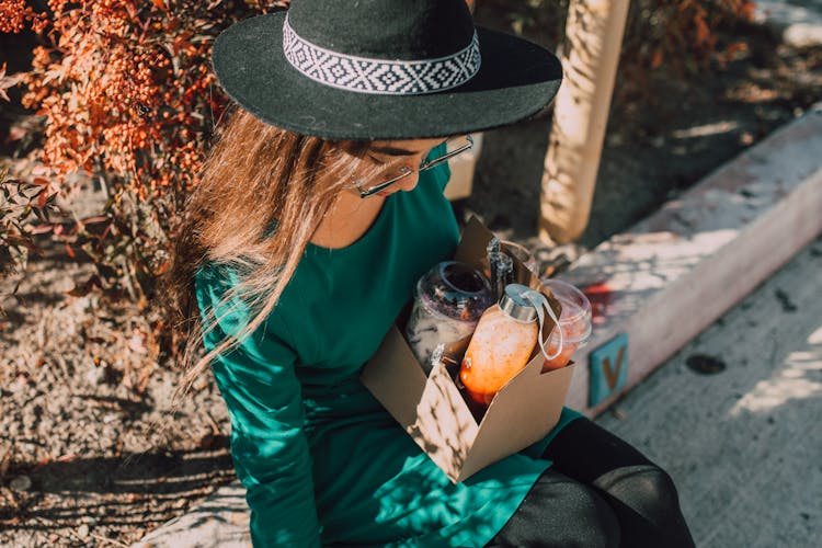 Woman With Black Hat Holding Assorted Refreshments