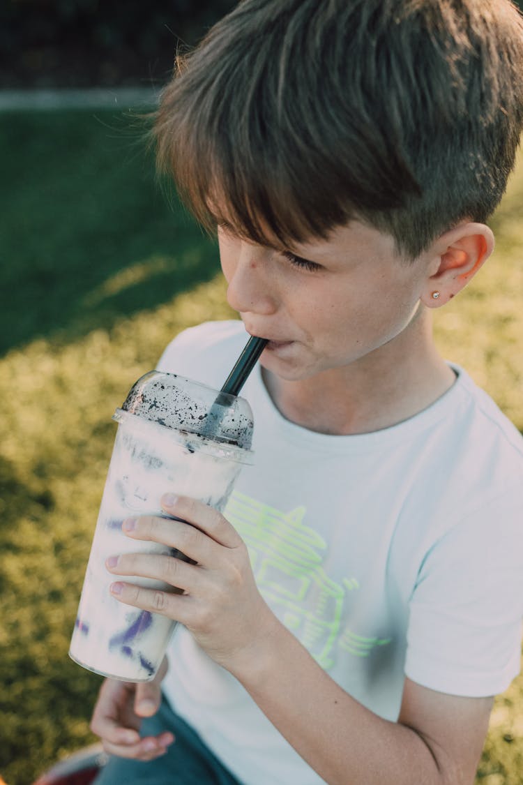 A Young Boy Drinking A Milkshake