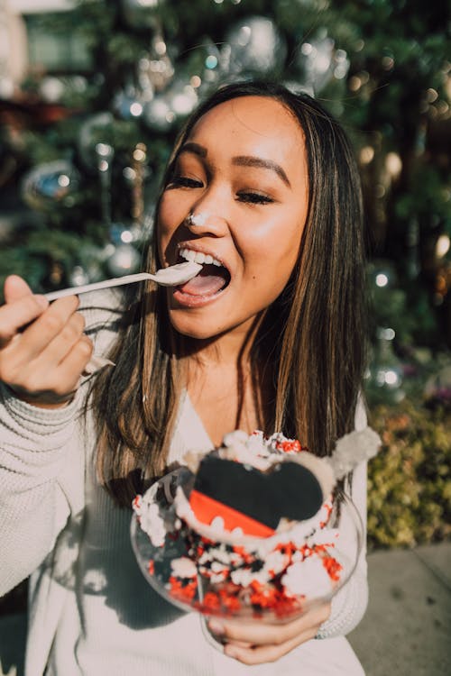 Woman in White Sweater Holding White and Red Strawberry Cake