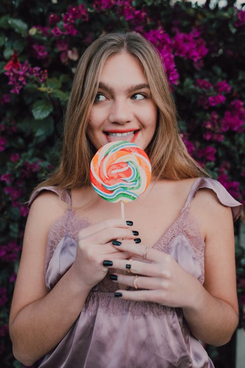 Woman in White Lace Tank Top Holding Lollipop