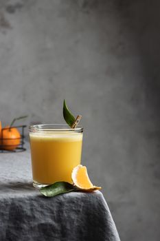 Glass of fresh orange juice with citrus slice on a table, creating a refreshing vibe.