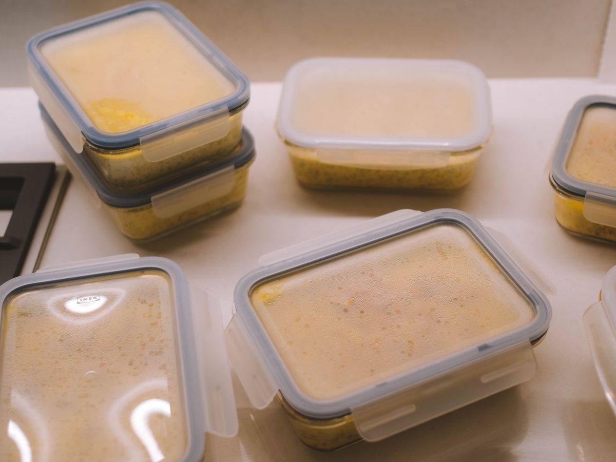 Individual portioned containers of cooked food lined up on a counter after a batch cooking session for one