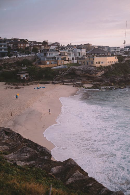 Houses located on hill near sandy seashore at sunset