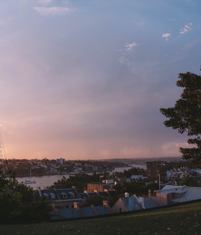 Picturesque scenery of cloudy sunset sky over sea and residential houses of peaceful town