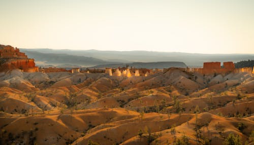 Scenic view of rocky rough canyon located amidst sandy dunes in spacious desert valley