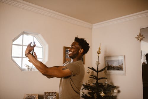 Free Smiling Man Having a Video Call Using a Cellphone Stock Photo