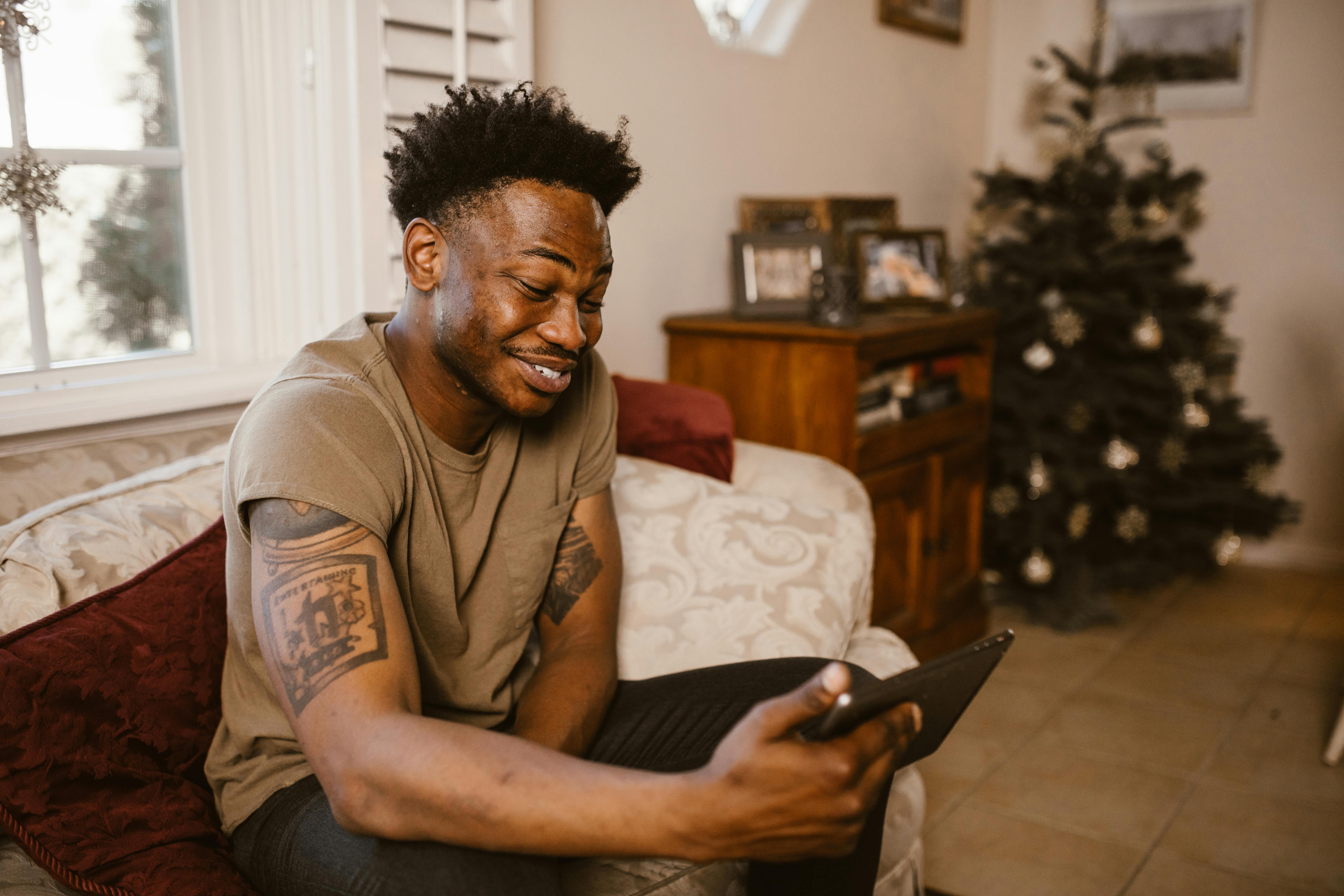 man sitting on couch while having a video call