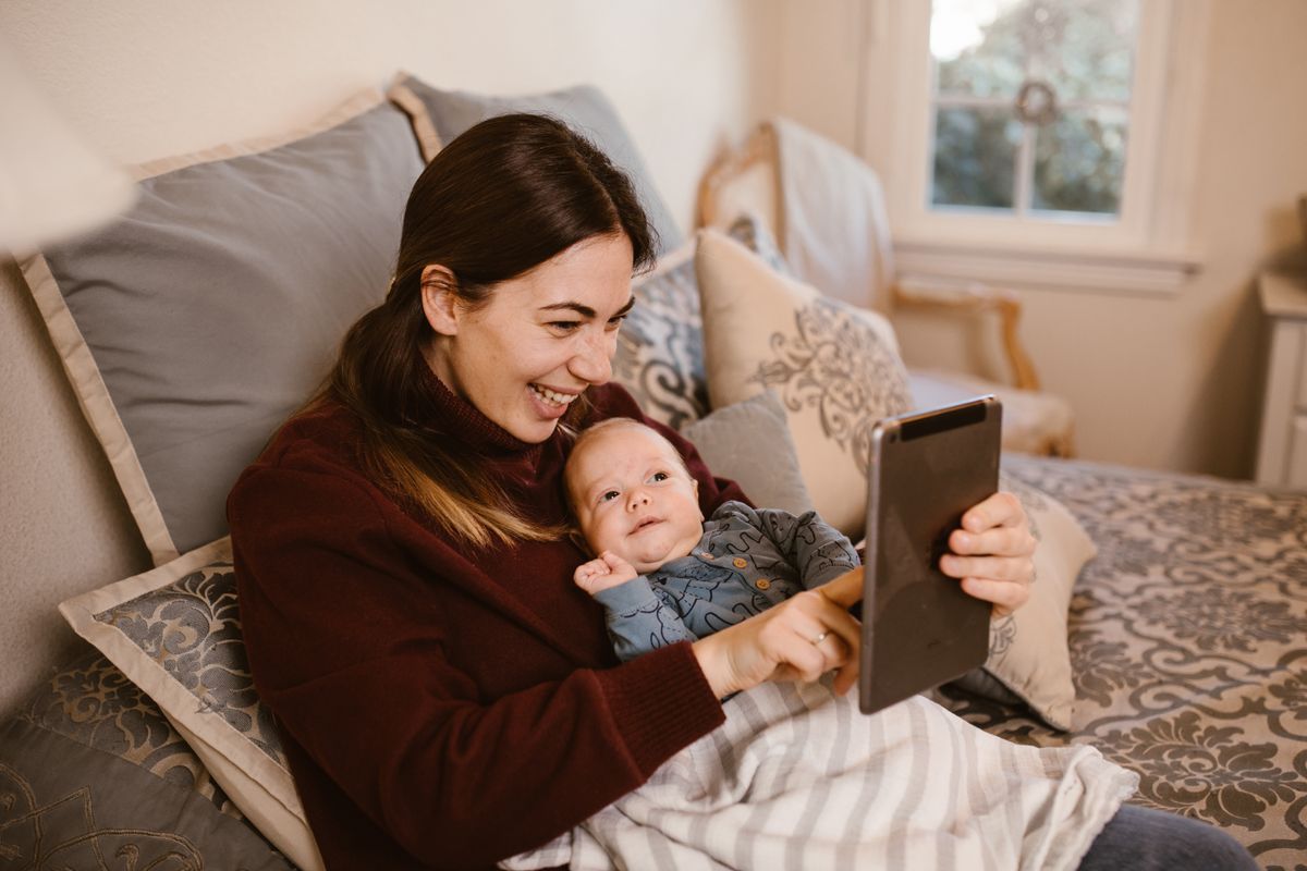 Mother holding her baby during a video call on a tablet